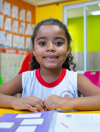 Aluna do Radeane sorrindo em sala de aula